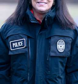 A woman in a dark colored police jacket.