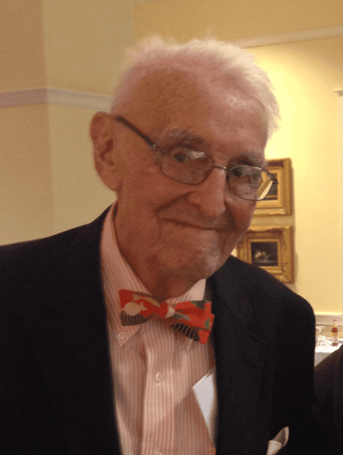 An up-close shot of Fisher Hower in glasses and a bowtie.
