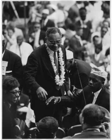 black and white photo of older man in crowd of people.