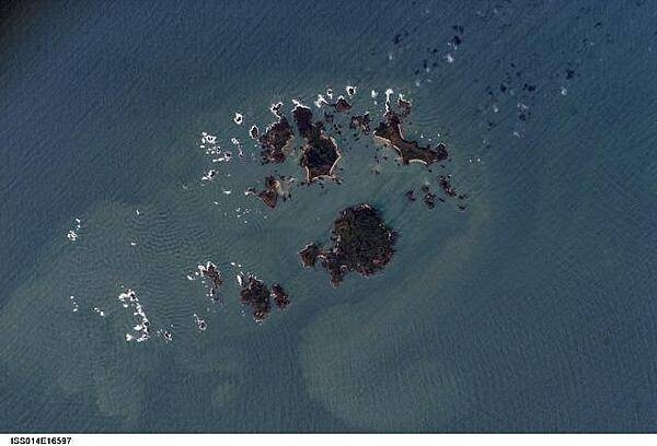 The Isles of Scilly, an archipelago of approximately 150 islands, are located some 45 km (28 mi) southwest of the westernmost point of England (Land's End). The islands are an erosional remnant of an ancient granite intrusion, and are notable because they have been inhabited for over 4,000 years. Only five of the islands are currently inhabited. Historical and geological evidence indicates that many of the islands were larger and/or connected in the recent past. Even today, it is possible to walk between certain islands during low tides. Image courtesy of NASA.