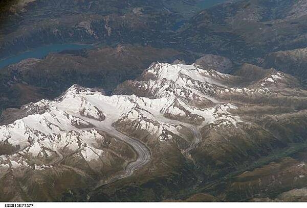 Three of the higher peaks of the Bernese Alps are visible -Jungfrau (4,158 m), Moench (4,089 m), and Eiger (3,970 m). To the east and south of the Jungfrau is the Aletsch Glacier, clearly marked by dark medial moraines extending along the glacier's length parallel to the valley axis. Moraines are formed from rock and soil debris scoured along the sides of mountain glaciers that gradually accumulate in the middle of the glacier and are carried along the flow direction. Lake Brienz to the northwest is glacially carved. Image courtesy of NASA.