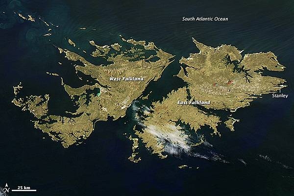 The Falkland Islands lie about 600 km (400 mi) east of Argentina and 1,350 km (850 mi) north of the Antarctic Circle. There are 778 islands in this territory of the United Kingdom, but just two large islands - East Falkland and West Falkland - comprise the bulk of the Connecticut-sized landmass.
Few trees grow on the islands. Instead, grassland and heath - which is widely used as pastureland for sheep and cattle - dominate the landscape. The islands are home to nearly 500,000 sheep and 5,000 cattle, and the animals far outnumber the 2,600 permanent human residents. About 80% of the population resides in the capital of Stanley.
Farmers often burn pastureland in the early spring to encourage growth. When ewes and lambs are born, they move the young animals to recently-burned areas to graze. This satellite image captures a glimpse of a few agricultural fires west of Stanley. Image courtesy of NASA.
