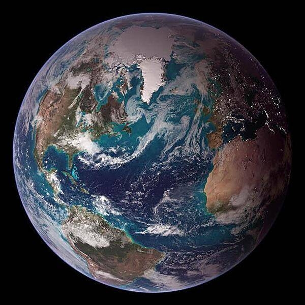 This "blue marble" image of the globe draws on data from multiple satellite missions (not all collected at the same time). The focus in this view is the North Atlantic Ocean and its surrounding land masses. Notice the thick ice pack on Greenland (top center) and the city lights on the night side of the globe. Image courtesy of NASA.