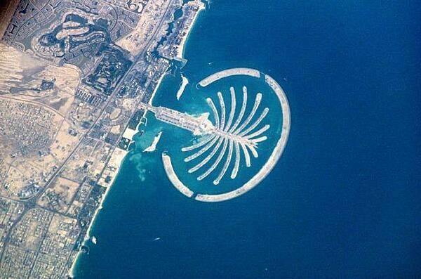 The artificial peninsula and islands that make up Palm Jumeirah in Dubai as seen from the International Space Station. This massive earthwork is reclaimed from Dubai's Persian Gulf coast. Advertised as "being visible from the Moon," the palm-shaped structure displays 17 huge fronds framed by an 11-km (7 mi) protective barrier. It is the first of three residential and commercial palm-shaped projects being undertaken in Dubai. Image courtesy of NASA.