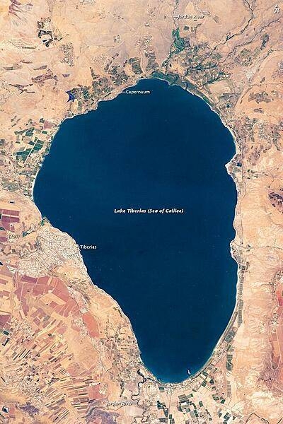 Israel's largest freshwater lake, Lake Tiberias, is also known as the Sea of Galilee. The lake measures just over 21 km (13 mi) north-south, and it is only 43 m (141 ft) deep. The lake is fed partly by underground springs related to the Jordan sector of the Great Rift Valley, but most of its water comes from the Jordan River, which enters from the north. The river's winding course can be seen draining the south end of the lake at image bottom. Angular green and brown field patterns clothe most hillsides in this arid landscape. Bright roof tops are the hallmark of several villages in the area. Much of the area to the east of the lake is part of the Israeli-occupied Golan Heights. Image courtesy of NASA.