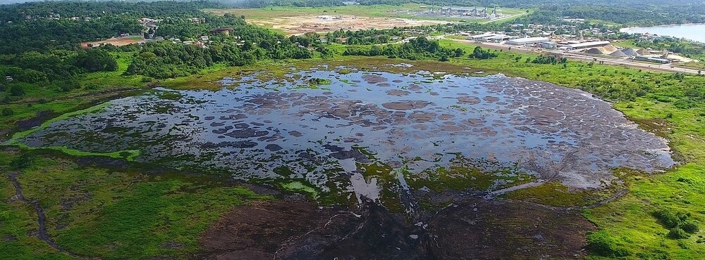 Pitch Lake is the world’s largest natural reservoir of asphalt and is located at La Brea on Trinidad's southwestern coast. It covers 100 acres (40 hectares) and has a depth of about 250 ft (80 m), with the asphalt reserves estimated to weigh more than six million tons.