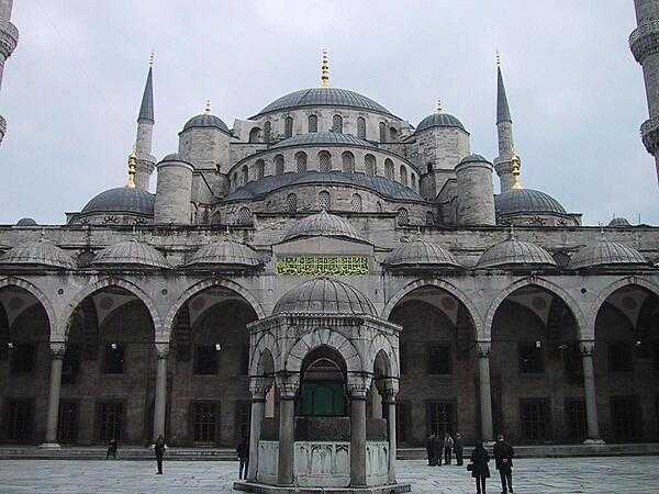 The Sultan Ahmed Mosque (also known as the Blue Mosque) in Istanbul is the national mosque of Turkey. Built between 1609 and 1617, during the rule of Sultan Ahmed I, the mosque stands next to the former Hippodrome of Constantinople (now Sultanahmet Square) and across from the Hagia Sophia. The mosque reflects the classical Ottoman layout with a central dome surrounded by four semi-domes over the prayer hall, except it has six minarets instead of the standard four, and can hold 10,000 worshipers. It is known as the “Blue Mosque” due to the thousands of blue Iznik tiles and painted floral motifs decorating its interior. The unique carved marble minbar (pulpit) is positioned so that the imam can be heard from anywhere in the mosque. The Sultan Ahmed Mosque became a UNESCO World Heritage Site in 1985.