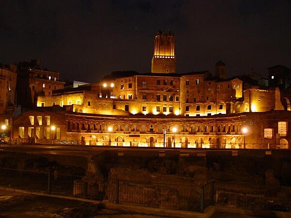 A nighttime view of Trajan's Market in Rome, Italy. Now a complex of ruins, it was built in A.D. 100-110. Its upper floor was filled with offices, and a road divided it  from the lower floor, which held shops.