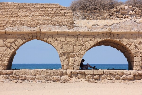 Present-day Caesarea is located midway between Tel Aviv and Haifa on the coastal plain of the Mediterranean Sea. The ancient city, known as Caesarea Maritima, was built by Herod the Great about 25–13 B.C. as a major port.  With no reliable source of fresh water, Herod commissioned a system of aqueducts (surviving section shown) to supply water from the springs of nearby Mount Carmel. With additions and repairs, the aqueducts delivered water for 1200 years, until canals were built. Today, Caesarea Maritima is a national park of the ancient city’s ruins, and one of Israel’s tourist attractions.