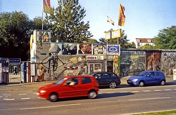 A preserved portion of the Berlin Wall in Germany. The wall was begun in 1961 and completely encircled West Berlin until 1989. The former wall is marked in some places by cobblestones.