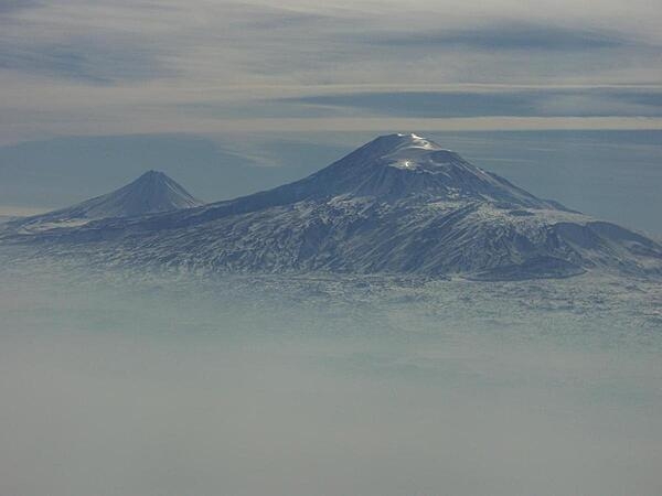 A view of Mount Ararat in western Turkey through the fog. The highest of its two peaks, Greater Ararat, is the tallest mountain in Turkey at 5,166 m (16,949 ft). Although located some 32 km (20 mi) from the Armenian border, the dormant volcano dominates the skyline of Yerevan, Armenia&apos;s capital. This photo was snapped after take off from the Yerevan airport.