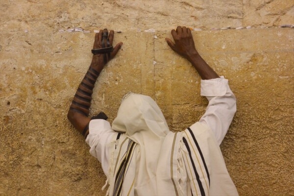 The Western Wall (also known as the Wailing Wall or Buraq Wall) is an ancient limestone wall in the Old City of Jerusalem. The wall was originally erected as part of the expansion of the Second Jewish Temple by Herod the Great in 19 B.C. These remains are considered holy to Jews as the temple was destroyed by the Romans in 70 A.D. The wall is now part of a larger wall that surrounds the Muslim Dome of the Rock and Al-Aqṣā Mosque. This photo depicts Jewish pilgrims in prayer.