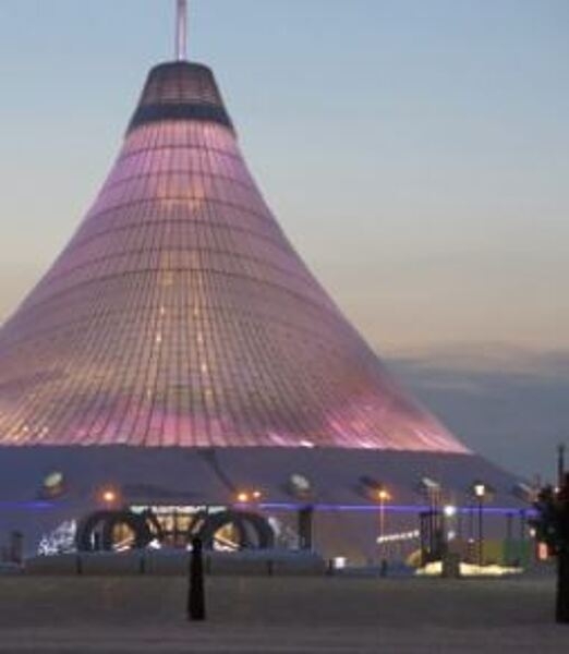 Khan Shatyr (Royal Marquee) is a transparent tent located in the capital city of Astana, Kazakhstan. Designed in a neofuturist style and built between 2006 and 2010, the 90 m- (300 ft-) high tent covers 140,000 sq m (35 acres). Beneath the canopy -- which covers an area larger than 10 football stadiums -- is a park, a shopping and entertainment venue with squares and cobbled streets, a boating river, a shopping center, a mini-golf center, and an indoor beach resort.