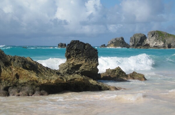 Horseshoe Bay Beach is named for its natural U-shape. The beach, bordered by limestone cliffs, has large reefs  as well as the famous Bermuda pink sand (the color derives from crushed shells and coral). Horseshoe Bay Beach is rated one of the most popular beaches in the world to visit and is the most photographed beach in Bermuda.