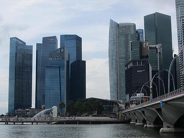 Skyline of the Singapore business district. The larger of two merlions (half-fish/half-lion creatures) may be seen spouting along the pier.