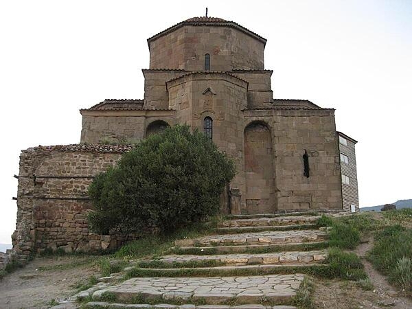 A UNESCO World Heritage Site since 1994, the Georgian Orthodox Jvari Monastery (Monastery of the Cross) at Mtskheta, Georgia, was built in the 6th century A.D.  The monastery is built in an early tetraconch (Greek for “four shells”) style, meaning the building is shaped like a cross with a dome and a connection to the natural environment around it. The monastery was the first church in Georgia or Armenia to be built in this style, which became common to the area. Sitting atop of Jvari Mount 656 m (2,152 ft) at the joining of the Mtkvari and Aragvi rivers, the monastery overlooks Mtskheta, the ancient capital of Caucasian Iberia in eastern Georgia.