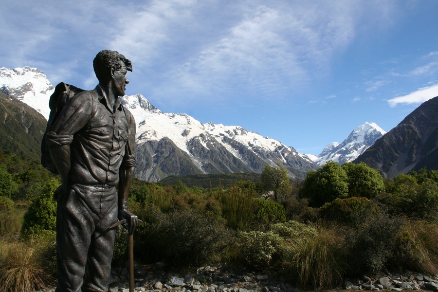 A memorial statue to Edmund Hillary in Aoraki/Mount Cook National Park (South Island, New Zealand) shows the explorer as a young man gazing toward the mountains. In 1953, Hillary was one of the first two people to successfully scale Mount Everest, Earth's tallest peak above sea level.  The monument recognizes the 50th anniversary of Hillary's ascent of Aoraki/Mount Cook in 1948.