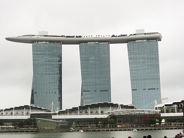 View of the Marina Bay Sands hotel complex in Singapore that opened in 2010 and has since become a city landmark. The upper-level Sky Park, built to resemble a ship, has the world's longest elevated swimming pool, as well as restaurants, gardens, and a public observation deck.