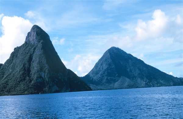 The Twin Pitons are the national symbol of Saint Lucia and appear on the flag. They are mountainous volcanic plugs (created when magma hardens within a vent on an active volcano).  Gros Piton is 798 m (2,619 ft) high and Petit Piton is 743 m (2,438 ft) high; both are located near the town of Soufriere, Saint Lucia. Photo courtesy of NOAA / Anthony R. Picciolo.
