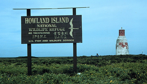 Sign on Howland Island noting its status as a wildlife refuge. The Earhart Light day beacon is on the right. Photo courtesy USFWS/C. Newton
