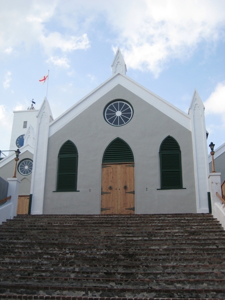 St. Peter’s Church, located in the UNESCO World Heritage Site of the Town of St. George, is the oldest Anglican Church outside the British Isles and the oldest church in continuous use in the New World. Established in 1612 when Bermuda was settled by the Virginia Company, the church was rebuilt many times due to stormy weather, and eventually constructed of stone in 1826. In 2012, for the Queen’s Diamond Jubilee year, St. Peter’s was granted the royal designation of “Their Majesties Chappell,” a title first used for the church during the reign of King William III and Queen Mary II. This title was often granted by monarchs to churches in their colonies.